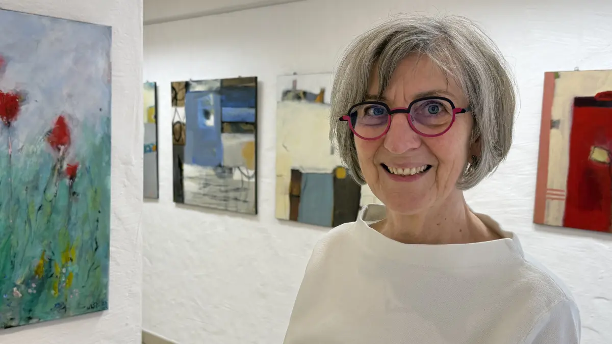Zwischen Gegenständlichkeit und Abstraktion: Ute Wagner-Zavaglia in ihrer Ausstellung. Links von ihr das Bild "Wiesenstück", hinter ihr das Bild "Rot".