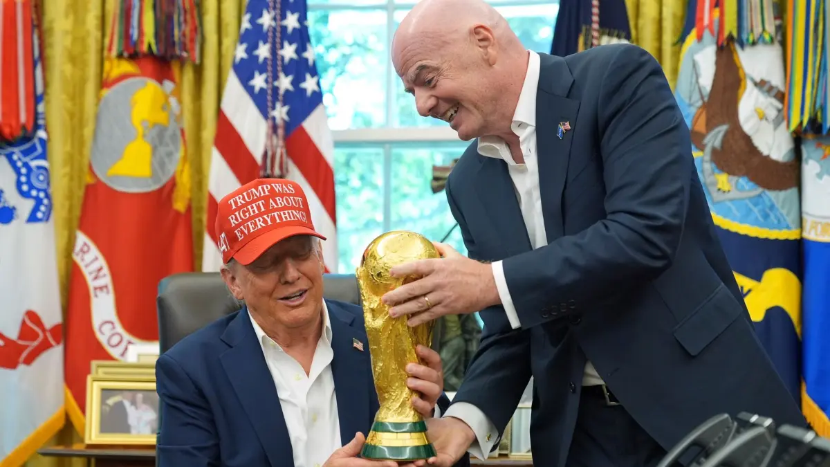 Donald Trump und Gianni Infantino: ARCHIV - 22.08.2025, USA, Washington: FIFA-Präsident Gianni Infantino (r) überreicht US-Präsident Donald Trump die FIFA World Cup Winners Trophy bei einer Ankündigung im Oval Office des Weißen Hauses. Ein Sonderbeauftragter des US-Präsidenten hat Italien als Iran-Ersatzteilnehmer vorgeschlagen. (zu dpa: «Italien statt Iran? US-Sonderbeauftragter mit WM-Vorschlag») Foto: Jacquelyn Martin/AP/dpa +++ dpa-Bildfunk +++