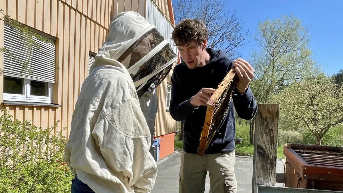 Imker Paul Lukhaub nimmt das Jungvolk mit den beiden Achtklässlerinnen Mila und Domenica genau unter die Lupe.