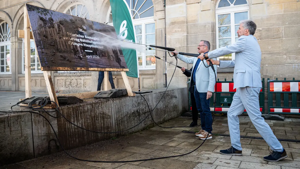 Kärchern statt Spatenstich: Oberbürgermeister Boris Palmer und Michael Groh, Leiter Regionalbereich Südwest, DB InfraGO AG, kärchern zum Start der Tübinger Bahnhofssanierung auf dem Bahnhofsvorplatz.