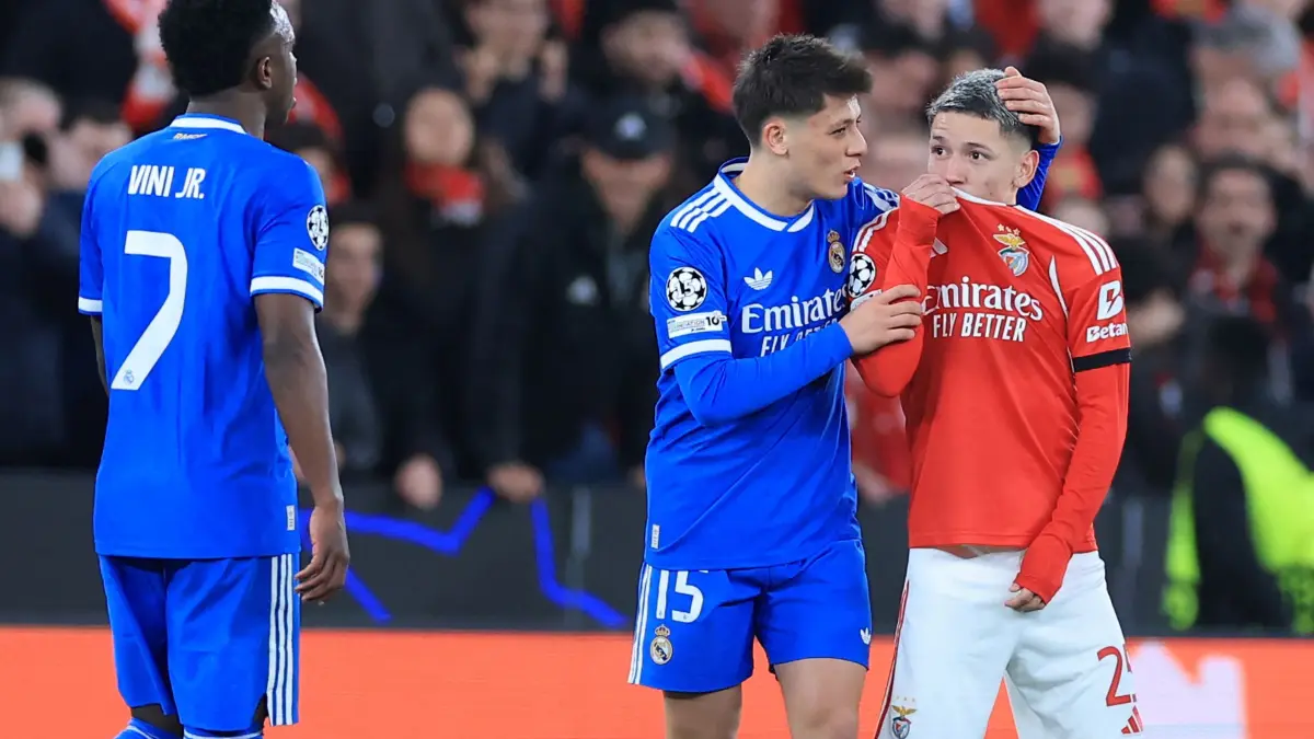 (FILES) (FILES) SL Benfica's Argentine forward #25 Gianluca Prestianni hides his mouth while arguing with Real Madrid's Brazilian forward #07 Vinicius Junior who complained about alleged racists insults during the UEFA Champions League knockout round play-off first leg football match between SL Benfica and Real Madrid CF at Estadio da Luz in Lisbon on February 17, 2026. UEFA banned Benfica winger Gianluca Prestianni for six matches on April 24, 2026 after a controversial incident in the Champions League clash against Real Madrid in February. The European football governing body said they had taken the decision to ban the Argentine "for discriminatory (i.e. homophobic) conduct", with three of those matches suspended for a two-year probationary period. (Photo by PATRICIA DE MELO MOREIRA / AFP)