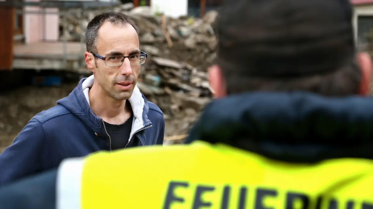 Braunsbach Bürgermeister Frank Harsch: Braunsbachs Bürgermeister Frank Harsch unterhält sich am Mittwoch, 8. Juni 2016 mit Einsatzkräften der Freiwilligen Feuerwehr aus Obersontheim. Braunsbach wurde schwer von der Unwetterkatastrophe und einer Flut am Sonntag, 29. Mai 2016 getroffen. Viele Häuser im Ort wurden schwer beschädigt. Der Schaden war insbesondere in der Orlacher Straße (Bild) am größten