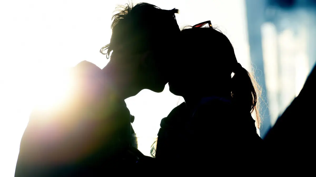 Junges Pärchen küsst sich im Licht des Sonnenuntergangs: ILLUSTRATION - Auch wenn es ähnlich viel Mut wie ein Bungeesprung kostet: Über sexuelle Wünsche zu sprechen, macht die Beziehung nur stärker und intimer. (zu dpa: «Langeweile im Bett: Wie spreche ich an, was mir Lust macht?») Foto: Alexander Körner/dpa/dpa-tmn - Honorarfrei nur für Bezieher des dpa-Themendienstes +++ dpa-Themendienst +++