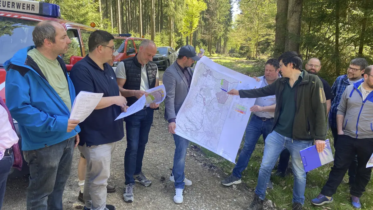 Böhmenkirch - „Sitzung“ im Wald: Tobias Traber (mit Kugelschreiber) von der Forstdirektion Freiburg erläutert dem Böhmenkircher Gemeinderat die Lage im derzeit noch von Fichten-Monokulturen geprägten Ochsenhau.
