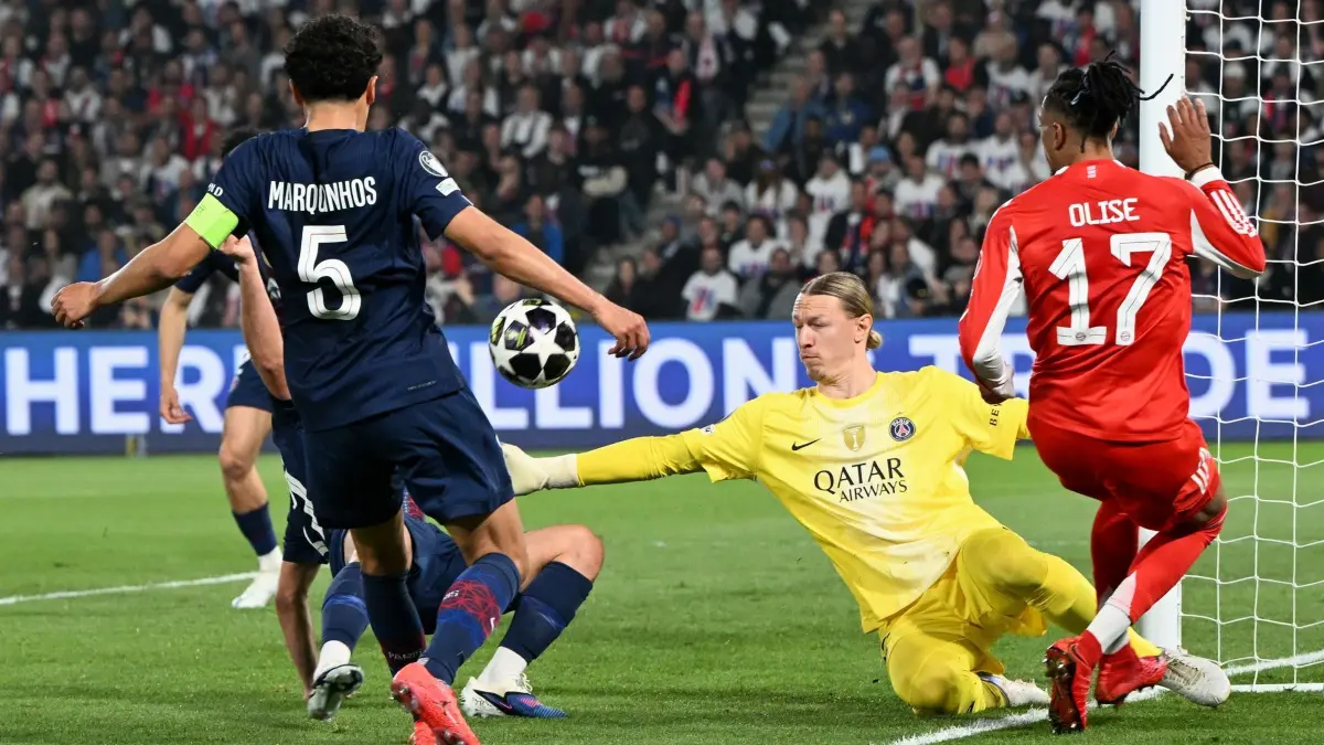 Paris Saint-Germain - Bayern München: 28.04.2026, Frankreich, Paris: Fußball, Männer: Champions League, Paris Saint-Germain - Bayern München, Halbfinale, Hinspiel, Parc des Princes, Torhüter Matvei Safonov (M, Paris Saint-Germain) in Aktion neben Marquinhos (l, Paris Saint-Germain) und Michael Olise (Bayern München). Foto: Federico Gambarini/dpa +++ dpa-Bildfunk +++