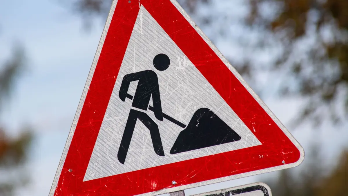 Ein zerkratztes Schild Gefahrzeichen Arbeitsstelle (Zeichen 123) mit dem Piktogramm eines Bauarbeiters zur Beschilderung einer Baustelle. (zu dpa: «Bauarbeiten auf wichtiger Hamburger Durchgangsstraße») +++ dpa-Bildfunk +++