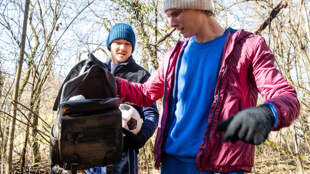Zwei junge Männer entdecken beim Fußballspielen eine Tasche. Der Inhalt offenbart ein Verbrechen, das die Polizei auf den Plan ruft.