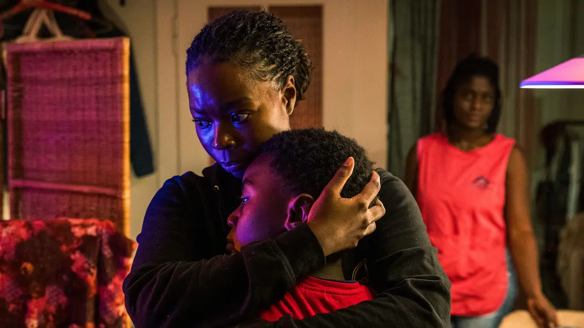Moya Alemu (Nambitha Ben-Mazwi, l.) und ihr Sohn Yaro Alemu (André Nkot Olinga, M.) kommen heimlich bei Sanaa Mukambo (Nancy Mensah-Offei) unter.