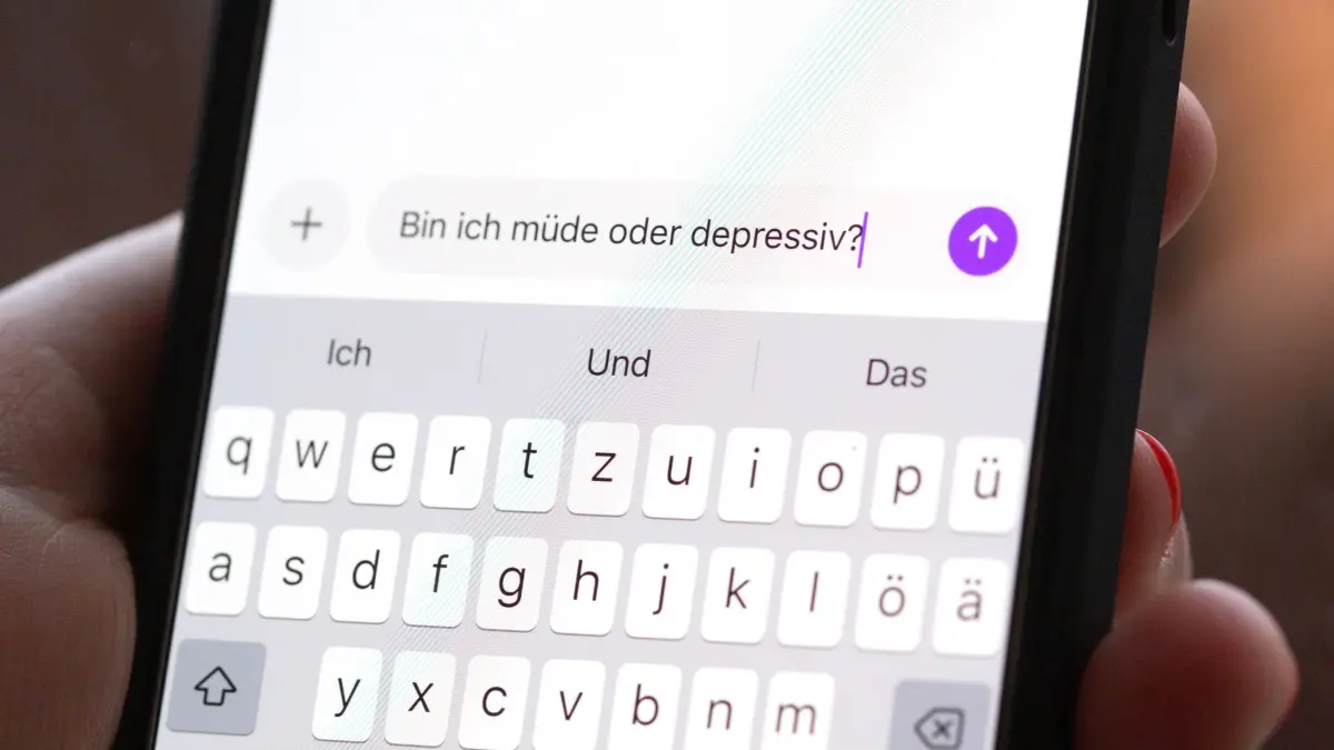 Illustration - Depression und Social Media: ILLUSTRATION - 24.11.2025, Berlin: Eine Person hält ein Smartphone in der Hand, auf dem eine Suchanfrage mit der Frage «Bin ich müde oder depressiv?» in einem KI-Chatfenster zu sehen ist. (gestellte Szene) Viele Menschen wenden sich zunehmend an KI-Anwendungen, um Einschätzungen zu Stimmung, Belastungen oder Veränderungen im Alltag zu erhalten. (zu dpa: «Zwei Drittel junger Menschen reden mit KI über psychische Belastungen») Foto: Fernando Gutierrez-Juarez/dpa +++ dpa-Bildfunk +++