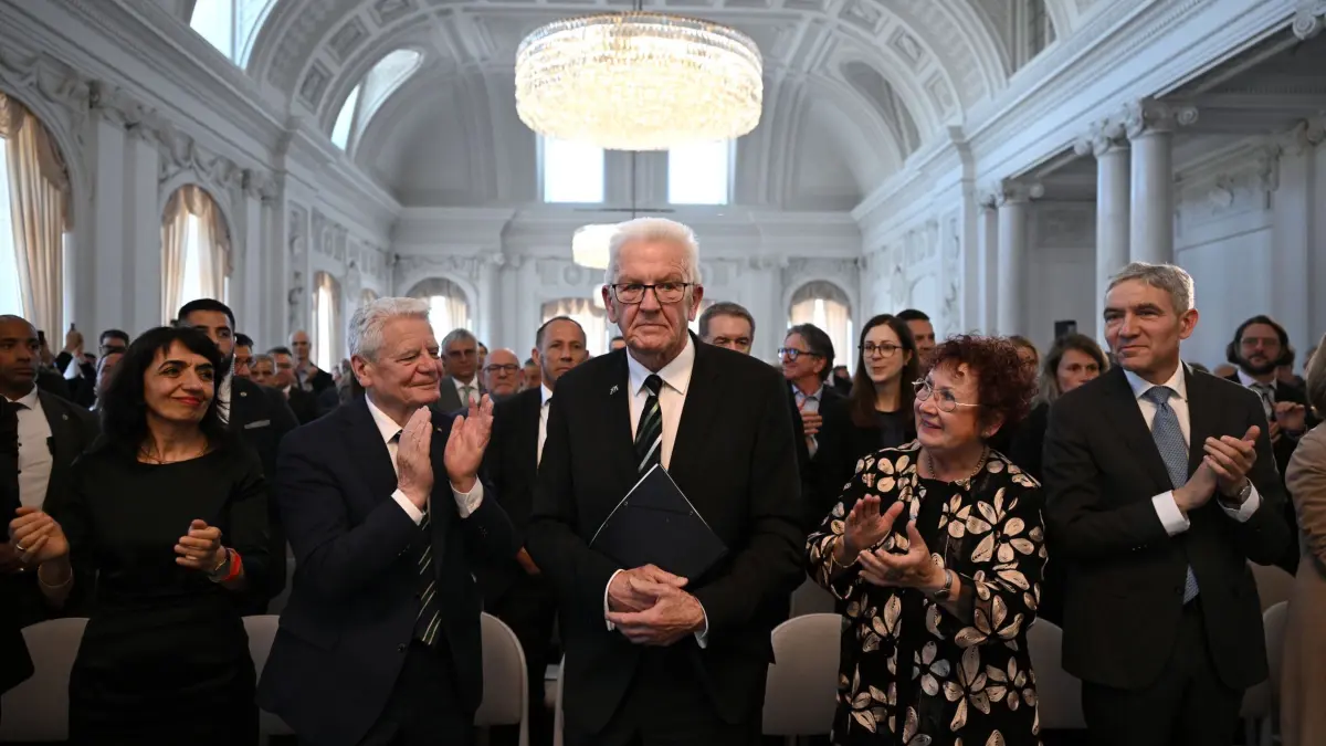 Festakt zur Verabschiedung von Ministerpräsident Kretschmann: 29.04.2026, Baden-Württemberg, Stuttgart: Winnfried Kretschmann (M, Grüne) bedankt sich bei den applaudierenden Gästen während des Festakts zu seiner Verabschiedung. Darunter Muhterem Aras (l-r, Grüne), Joachim Gauck, ehemaliger Bundespräsident und seiner Ehefrau Gerlinde Kretschmann (2.vr). Die Amtszeit von Ministerpräsident Winfried Kretschmann ist fast zu Ende. Er wird im Neuen Schloss in Stuttgart feierlich verabschiedet. Foto: Marijan Murat/dpa +++ dpa-Bildfunk +++