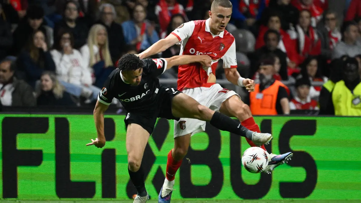 Freiburg's German forward #07 Derry Scherhant (L) vies for the ball with Sporting Braga's Swedish defender #14 Gustaf Lagerbielke during the UEFA Europa League semi final first leg football match between SC Braga and SC Freiburg at Municipal stadium of Braga on April 30, 2026. (Photo by Miguel RIOPA / AFP)
