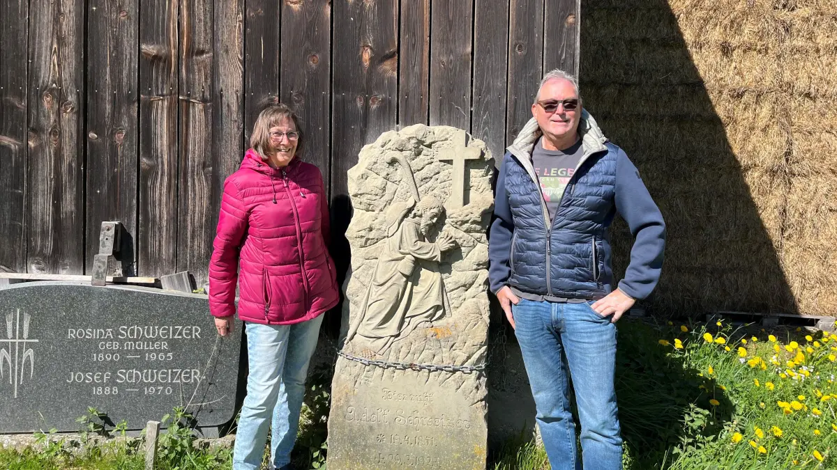 Renate Langer, (geborene Schweizer) und Werner Schweizer vor dem Grabstein von Adolf Schweizer, ihrem Urgroßvater.