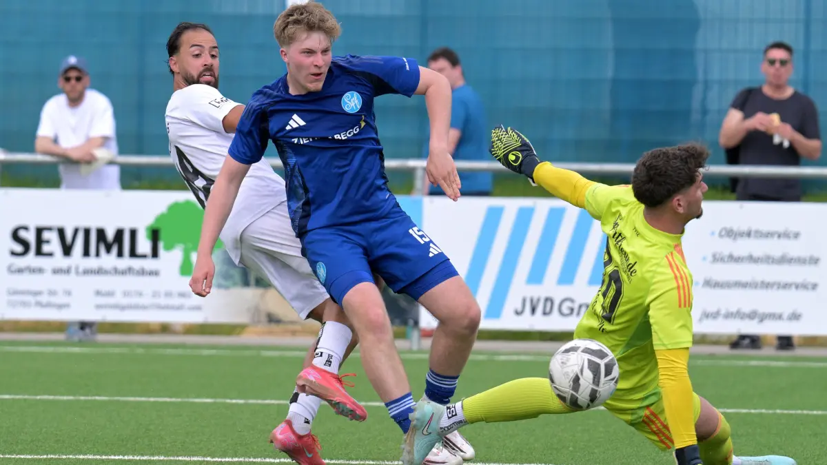 Fussball VL | Young Boys Reutlingen vs. Spfr. Schwaebisch Hall: Fussball VL | Young Boys Reutlingen (weiss) vs. Spfr. Schwaebisch Hall (blau) // 2026-05-03 // Foto: Joachim Baur // #18 Adil Iggoute (Young Boys Reutlingen) mit dem Schuss zum 2:0 / #15 Lukas Hahn (Schw. Hall) / TW #30 Bojan Spasojevic (Schw. Hall)