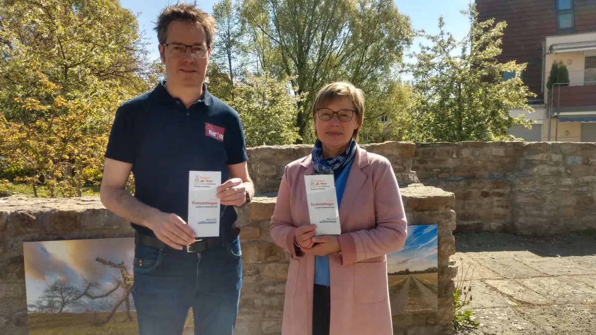 Dekanatsreferent Achim Wicker und Pfarrerin Birgit Wurster präsentieren den Flyer mit den Veranstaltungen mit den Veranstaltungen.