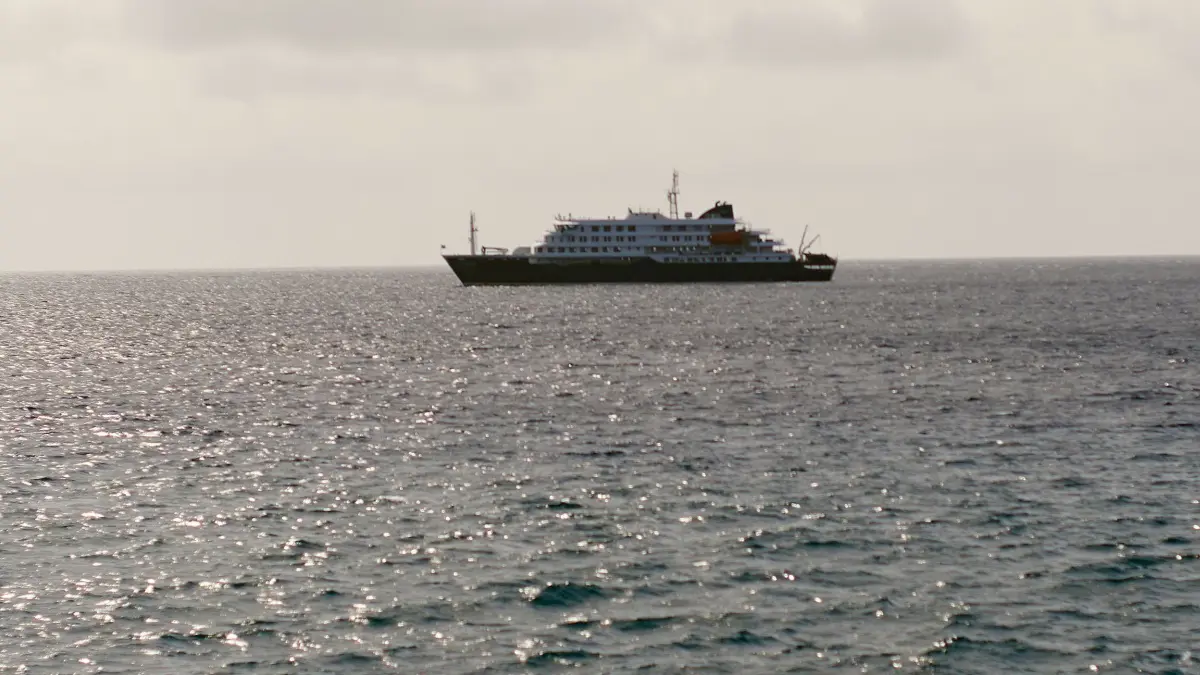 Drei Tote nach Hantavirus-Ausbruch auf Kreuzfahrtschiff: 05.04.2026, Kap Verde, Praia: WIEDERHOLUNG MIT ENGEREM BILDAUSSCHNITT - Ein Blick auf das Kreuzfahrtschiff Hondius bei Praia, Kap Verde. Nach einem ungewöhnlichen Ausbruch des Hantavirus auf dem kleinen Kreuzfahrtschiff im Atlantik sind laut Weltgesundheitsorganisation (WHO) drei Menschen mutmaßlich nach einer Infektion gestorben. Foto: Arilson Almeida/AP/dpa +++ dpa-Bildfunk +++