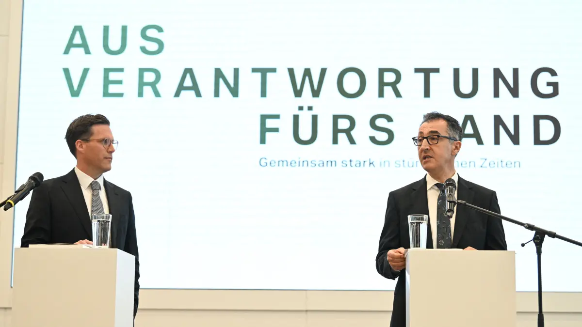 Cem Oezdemir (R) of the Greens and Manuel Hagel, chairman of the Christian Democratic Union (CDU) party in the southern federal state of Baden-Wuerttemberg, address the press to present their coalition contract following the federal state's elections, in Stuttgart, southern Germany, on May 6, 2026. (Photo by THOMAS KIENZLE / AFP)