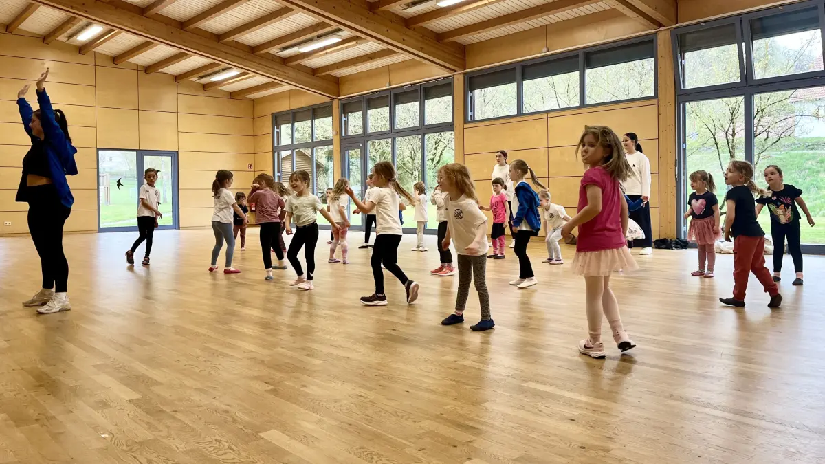 Die Youngsters, Mädchen zwischen drei und sechs Jahre, tanzen in der Weinberghalle Mittelfischach. Die drei Trainerinnen Lilly Hofmann (vorne in blau), Nele Ostertag (hinten rechts in weiß) und Aaliyah Burgaz machen die Schritte vor und erklären sie kindgerecht.