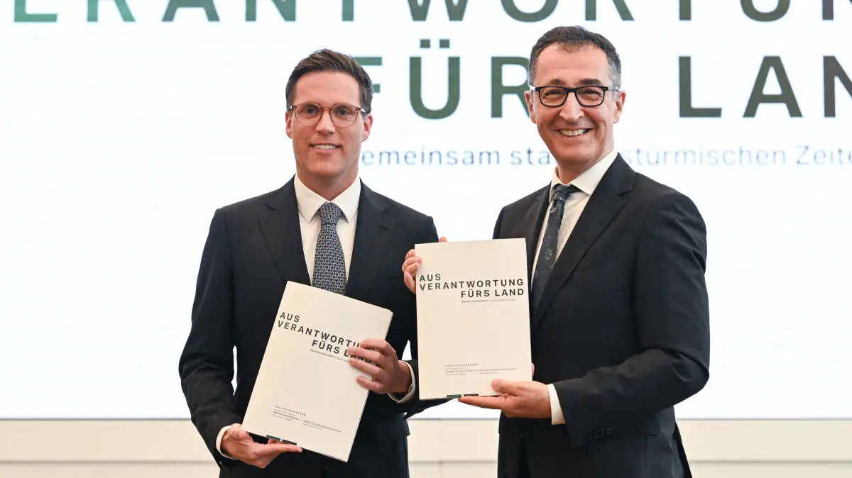 Cem Oezdemir (R) of the Greens and Manuel Hagel, chairman of the Christian Democratic Union (CDU) party in the southern federal state of Baden-Wuerttemberg, present their parties' coalition contract following the federal state's elections, in Stuttgart, southern Germany, on May 6, 2026. (Photo by THOMAS KIENZLE / AFP)