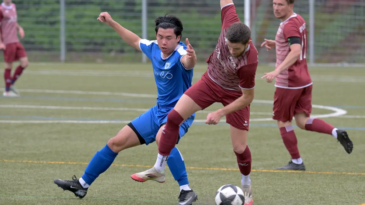 Fussball BL | SG Reutlingen vs. SGM Dettingen/Glems: Fussball BL | SG Reutlingen (rot) vs. SGM Dettingen/Glems (blau) // 2026-05-10 // Foto: Joachim Baur // #7 Simon Hanle (SG Reutlingen) / #16 Duy Truoug (SGM Dettingen-Glems)