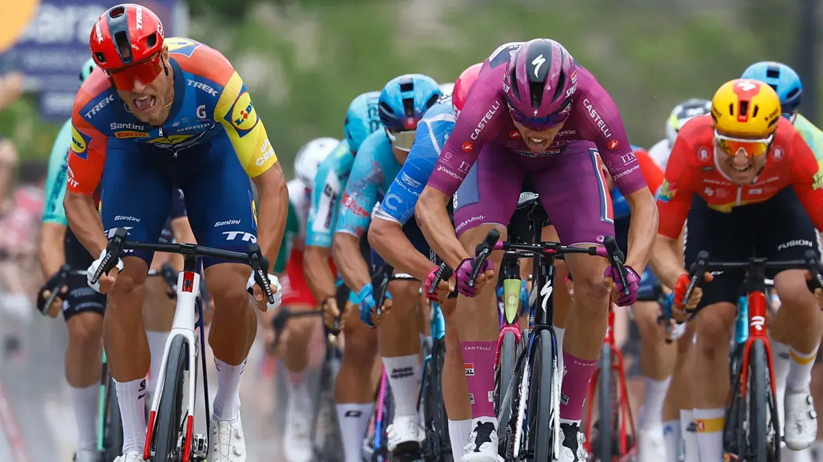 Cycling: 2026 World Tour, Giro d'Italia: Stage 3: Plovdiv - Sofia 175.0 km: Soudal Quick-Step French rider Paul Magnier (C) wearing the points classification mauve jersey (Maglia Ciclamino) celebrates as he crosses the finish line next to Lidl - Trek Italian rider Jonathan Milan to win the 3nd stage of the Giro d'Italia 2026 - Tour of Italy cycling race between Plovdiv and Sofia, Bulgaria, on May 10, 2026. (Photo by Luca Bettini / AFP)