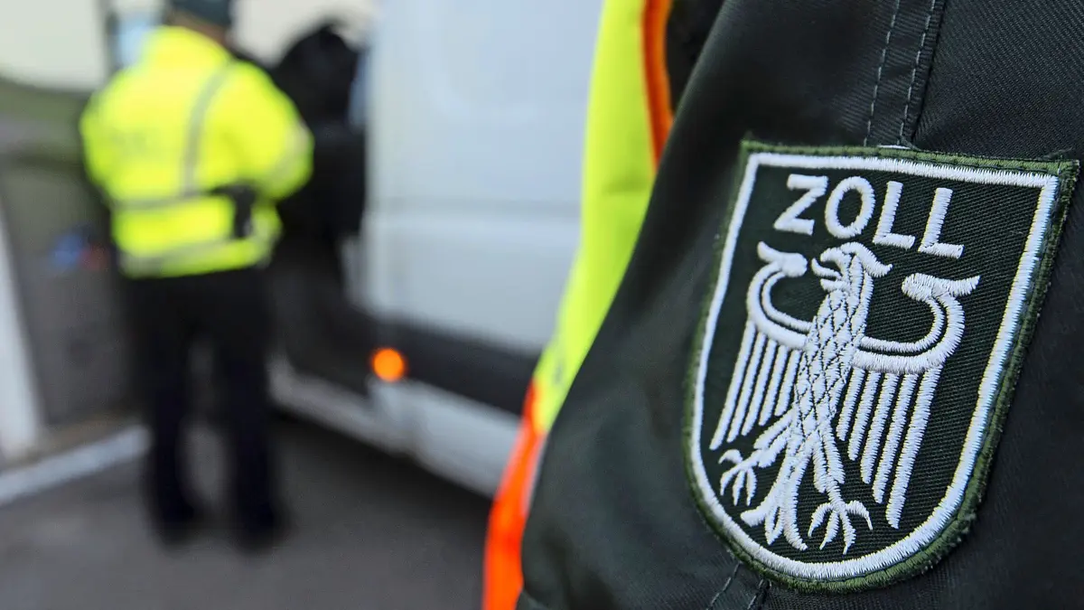 Ein Zollbeamter überprüft am 24.03.2015 in der Nähe des Grossmarktes in Stuttgart (Baden-Württemberg) einen Fahrer eines Kleintransporters. Seit Jahresbeginn gilt bundesweit ein Mindestlohn von 8,50 Euro pro Stunde. Ob der auch tatsächlich gezahlt wird, kontorlliert der Zoll - und rückt dabei schon mal im Morgengrauen aus. Foto: Daniel Maurer/dpa (zu lsw Korr: ««Prüfobjekt: Großmarkt» - Mindestlohn-Kontrolle mit dem Zoll» vom 30.03.2015) +++(c) dpa - Bildfunk+++