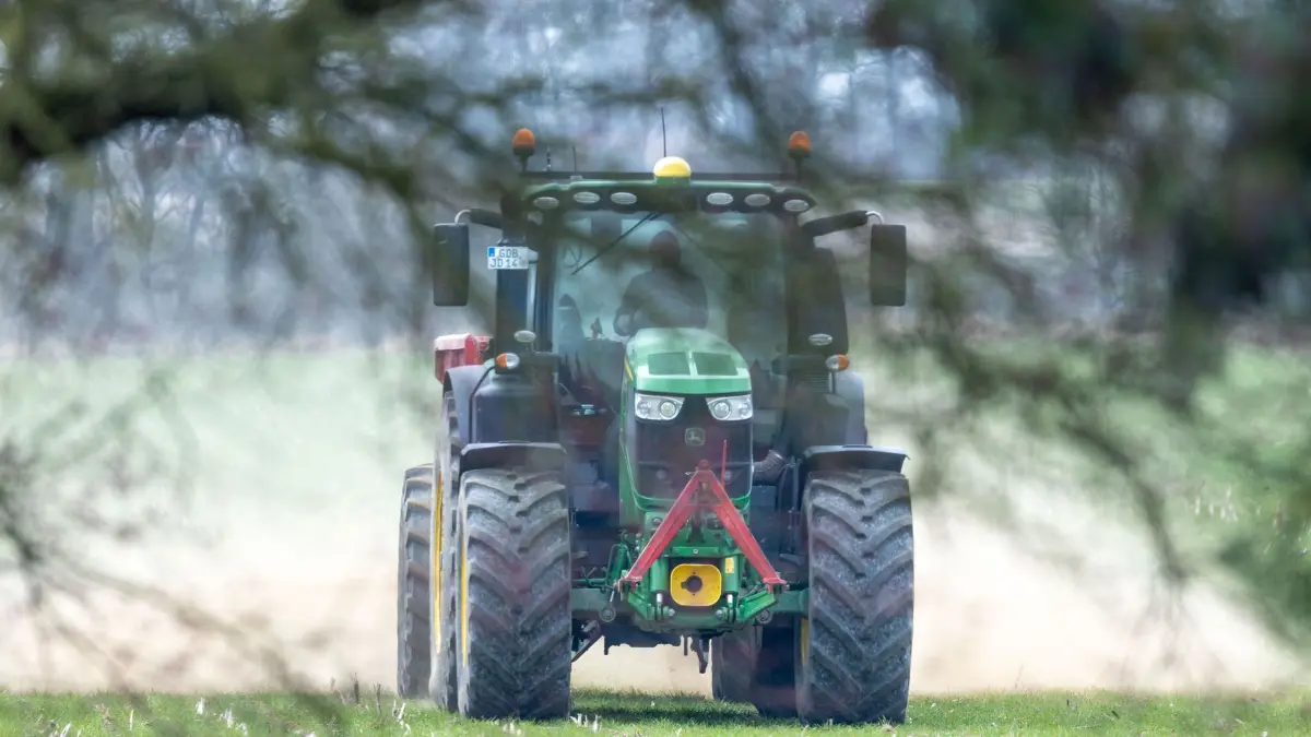 Düngen in der Landwirtschaft: ARCHIV - 24.03.2026, Mecklenburg-Vorpommern, Lützow: Ein Traktor fährt mit einem Streuwagen über ein Feld und verteilt Dünger. (zu dpa: «Teurer Dünger: EU-Kommission will Bauern mehr Geld geben») Foto: Jens Büttner/dpa +++ dpa-Bildfunk +++