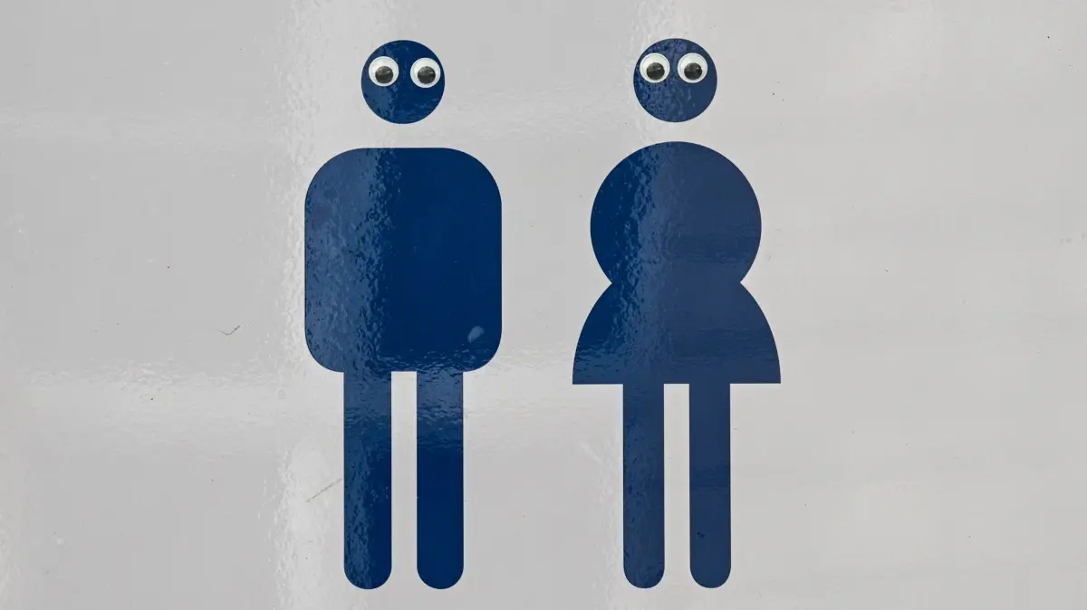 Toilettenschild: ARCHIV - 08.04.2024, Berlin: Ein Schild Mann und Frau mit einem Pfeil weist auf die Toiletten hin. Die Piktogramme sind mit Augen beklebt. (zu dpa: «Das Schulklo, eine No-go-Area? Ein Webportal bietet Hilfe») Foto: Jens Kalaene/dpa +++ dpa-Bildfunk +++