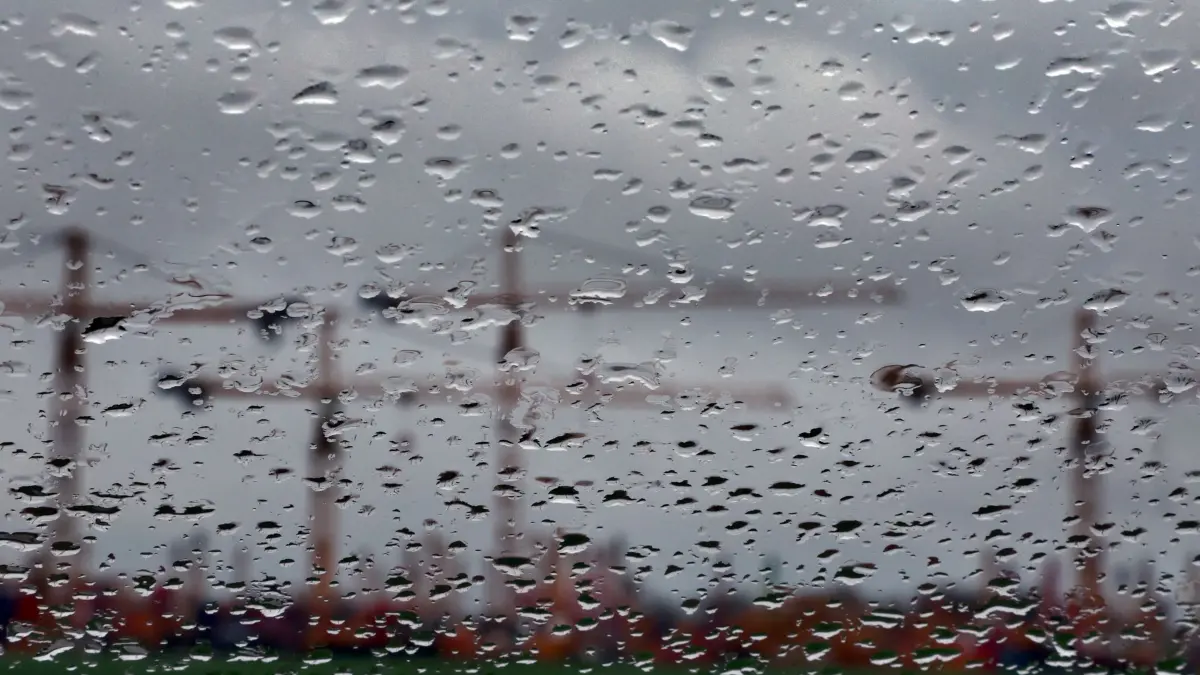 Trübe Konjunkturaussichten: ARCHIV - 18.03.2024, Bayern, Mindelheim: Hinter einer regennassen Scheibe sind Baukräne auf dem Gelände eines Kranservice unter dichten Wolken zu sehen. (zu dpa: «Trübe Aussichten für bayerische Wirtschaft») Foto: Karl-Josef Hildenbrand/dpa +++ dpa-Bildfunk +++