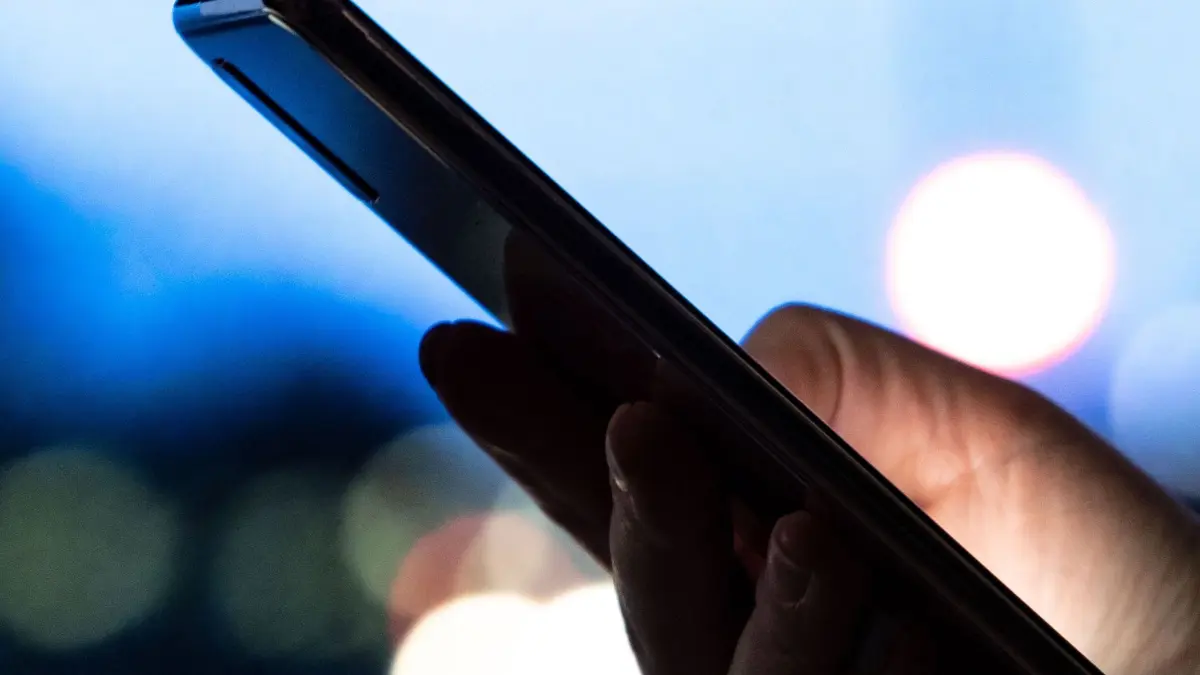 Frau hält ein Smartphone in der hand: ILLUSTRATION - MMS-Dämmerung mangels Nachfrage: Vodafone hat den Dienst bereits abgeschaltet, am 30. Juni ziehen auch Telekom, Telefónica (o2) und 1&1 den Stecker. (zu dpa: «MMS-Nachrichten verschwinden endgültig») Foto: Laura Ludwig/dpa-tmn - Honorarfrei nur für Bezieher des dpa-Themendienstes +++ dpa-Themendienst +++