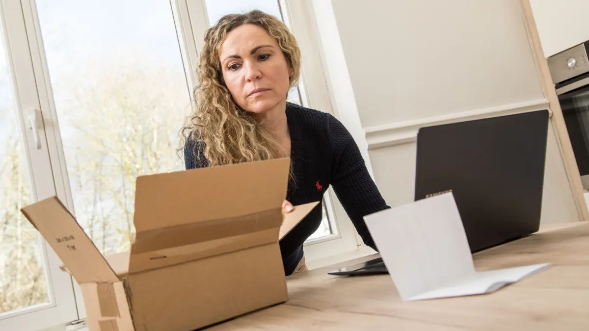 Frau schaut in den Karton einer Online-Lieferung: ILLUSTRATION - Auch wenn man erst nach der Annahme des Pakets merkt, dass es leer ist, gilt: Hat man keine Ware erhalten, haftet der Händler. (zu dpa: «Online bestellt und leeres Paket bekommen - was ist zu tun?») Foto: Christin Klose/dpa-mag - Honorarfrei nur für Bezieher des Dienstes dpa-Magazin +++ dpa-Magazin +++