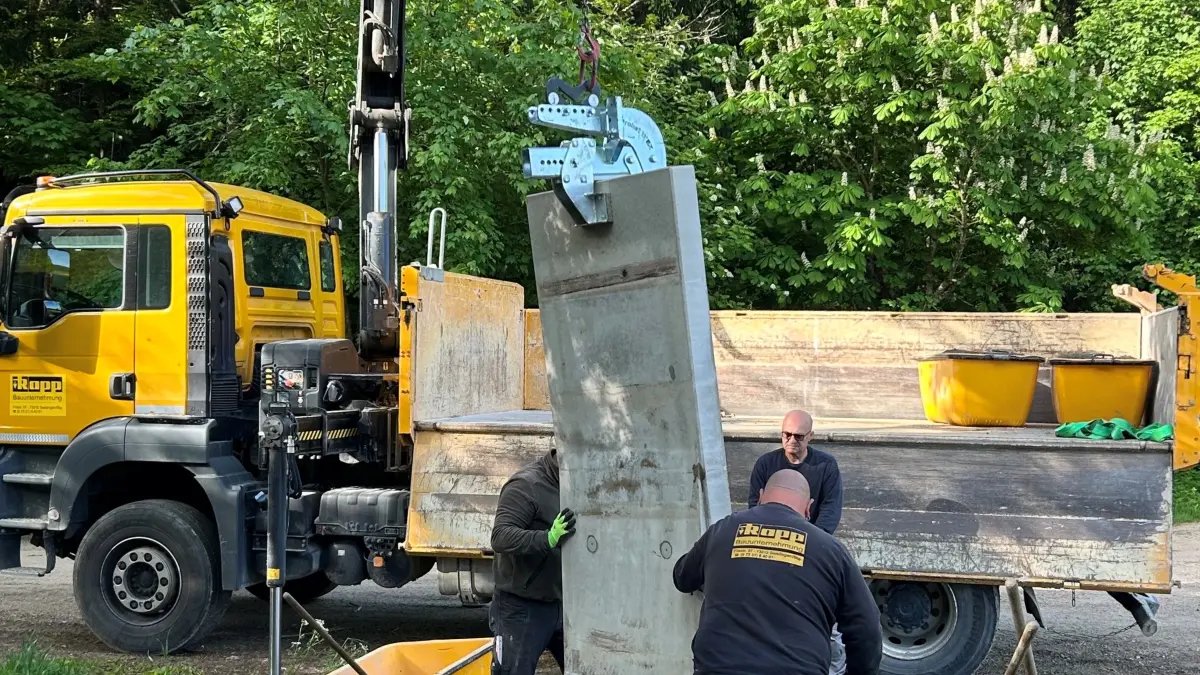 Ein Kranwagen der Firma Rapp hat die Stele für das Mahnmal von Jan Budzyn hertransportiert und abgeladen, Mitarbeiter sorgen für die Standsicherheit des Mahnmals. Revierförster Gottfried Schön hatte den Platz am Waldrain vorbereitet. Bald wird nun die Gedenktafel an der Stele angebracht.
