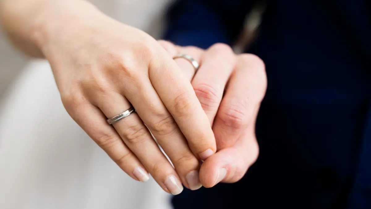Ein Hochzeitspaar hält sich bei der Hand: ARCHIV - Nach Heirat und Namensänderung einfach weiter mit dem Geburtsnamen unterschreiben? Keine gute Idee. Denn das ist mindestens eine Ordnungswidrigkeit, wenn nicht sogar eine Straftat. (zu dpa: «Muss der Arbeitgeber wissen, dass ich geheiratet habe?») Foto: Rolf Vennenbernd/dpa/dpa-mag - Honorarfrei nur für Bezieher des Dienstes dpa-Magazin +++ dpa-Magazin +++