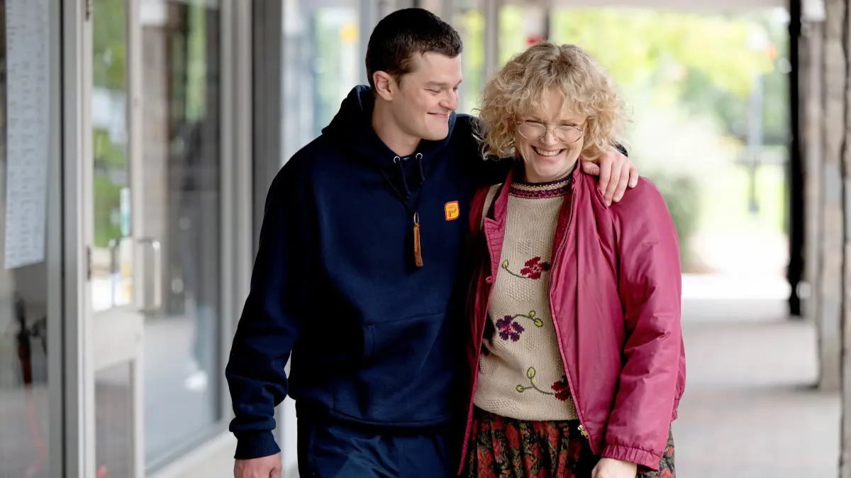 Der Film „Verflucht normal“ kommt in die Kinos: Robert Aramayo als John Davidson und Maxine Peake als Dottie Achenbach in dem Film "Verflucht normal", der am Donnerstag (28.05.2026) in die Kinos kommt. Als John Davidson von Koenigin Elizabeth II. persoenlich fuer seinen Einsatz gewuerdigt wird, ueber die neuropsychiatrische Krankheit aufzuklaeren, an der er leidet, sprengt er die Feierlichkeiten mit dem unfreiwilligen Ausruf: "F*** the Queen" – Tourette kennt eben keine Tabus. "Verflucht normal" erzaehlt seine Geschichte. Der 1971 in Schottland geborene John erfaehrt als Kind Zuhause und in der Schule Haenselei, Gewalt und Ausgrenzung. Auch als junger Erwachsener verfolgt ihn noch das Unverstaendnis der Umwelt. Als er seinen ehemaligen Mitschueler Murray (Francesco Piacentini-Smith) und dessen Mutter wiederbegegnet und sie ihn mit Verstaendnis und Empathie behandeln, geht es bergauf. John beginnt, Unverstaendnis mit Aufklaerung zu begegnen und wird zum Aktivisten. (Siehe epd-Filmkritik vom 26.05.2026) -- ACHTUNG: VEROEFFENTLICHUNG DES FOTOS NUR IM ZUSAMMENHANG MIT BERICHTERSTATTUNG UEBER DEN FILM SECHS WOCHEN NACH START DES FILMS GESTATTET