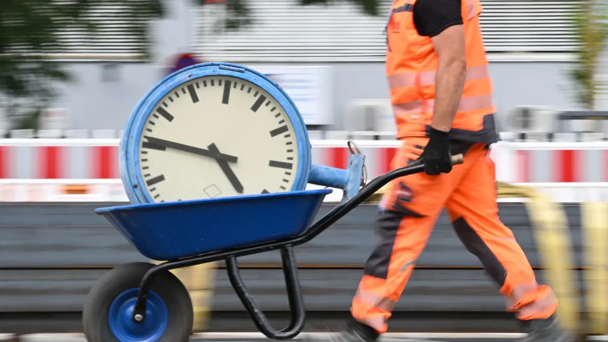 Jeder Zweite wünscht sich kürzere Arbeitszeiten: ARCHIV - 17.07.2024, Hessen, Mörfelden-Walldorf: Ein Arbeiter transportiert eine Bahnhofsuhr auf einer Schubkarre. Mehr als jeder zweite Beschäftigte in Deutschland wünscht sich kürzere Arbeitszeiten (zu dpa: «Jeder Zweite wünscht sich kürzere Arbeitszeiten») Foto: Arne Dedert/dpa +++ dpa-Bildfunk +++