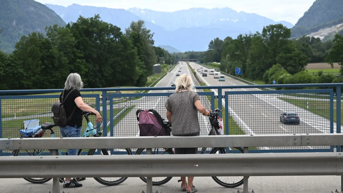 Demo auf Brennerautobahn - Deutschland: 30.05.2026, Bayern, Brannenburg: Betty und Burgi aus Neubeuern stehen mit Fahrrädern auf einer Brücke über der A8 und schauen auf den ruhig dahinfließenden Verkehr Richtung Brenner. Die Brennerautobahn in Tirol, Österreich, ist für eine Anwohner-Demonstration für mehrere Stunden gesperrt. Die Anwohner protestieren gegen die seit Jahren wachsende Verkehrsflut. Foto: Felix Hörhager/dpa +++ dpa-Bildfunk +++