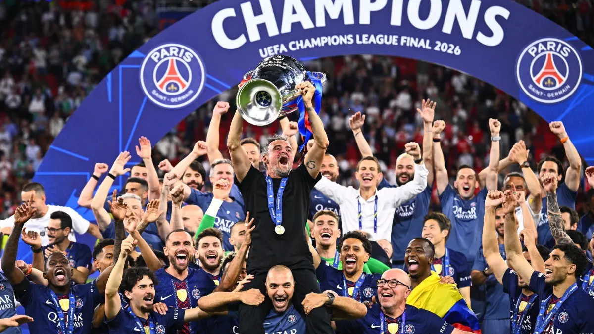 Paris Saint-Germain - FC Arsenal: 30.05.2026, Ungarn, Budapest: Fußball, Männer: Champions League, Paris Saint-Germain (PSG) - FC Arsenal, Finale, Puskás Aréna, Trainer Luis Enrique (M, Paris Saint-Germain) jubelt nach dem Sieg im Elfmeterschießen mit der Champions League Trophäe, während seine Spieler feiern. Foto: Tom Weller/dpa +++ dpa-Bildfunk +++