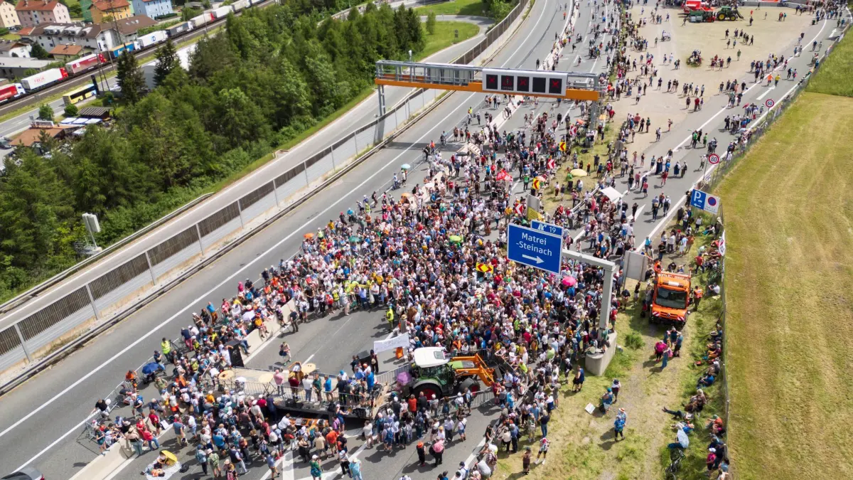 Demonstration und Totalsperre auf Brennerautobahn: 30.05.2026, Österreich, Matrei Am Brenner: Zahlreiche Menschen demonstrieren auf der gesperrten Brennerautobahn. Wegen einer Demonstration auf der Brennerautobahn ist die wichtigste Verkehrsverbindung zwischen Deutschland und Italien in beide Richtungen nahezu vollständig blockiert. (Luftaufnahme mit einer Drohne) Foto: Peter Kneffel/dpa +++ dpa-Bildfunk +++