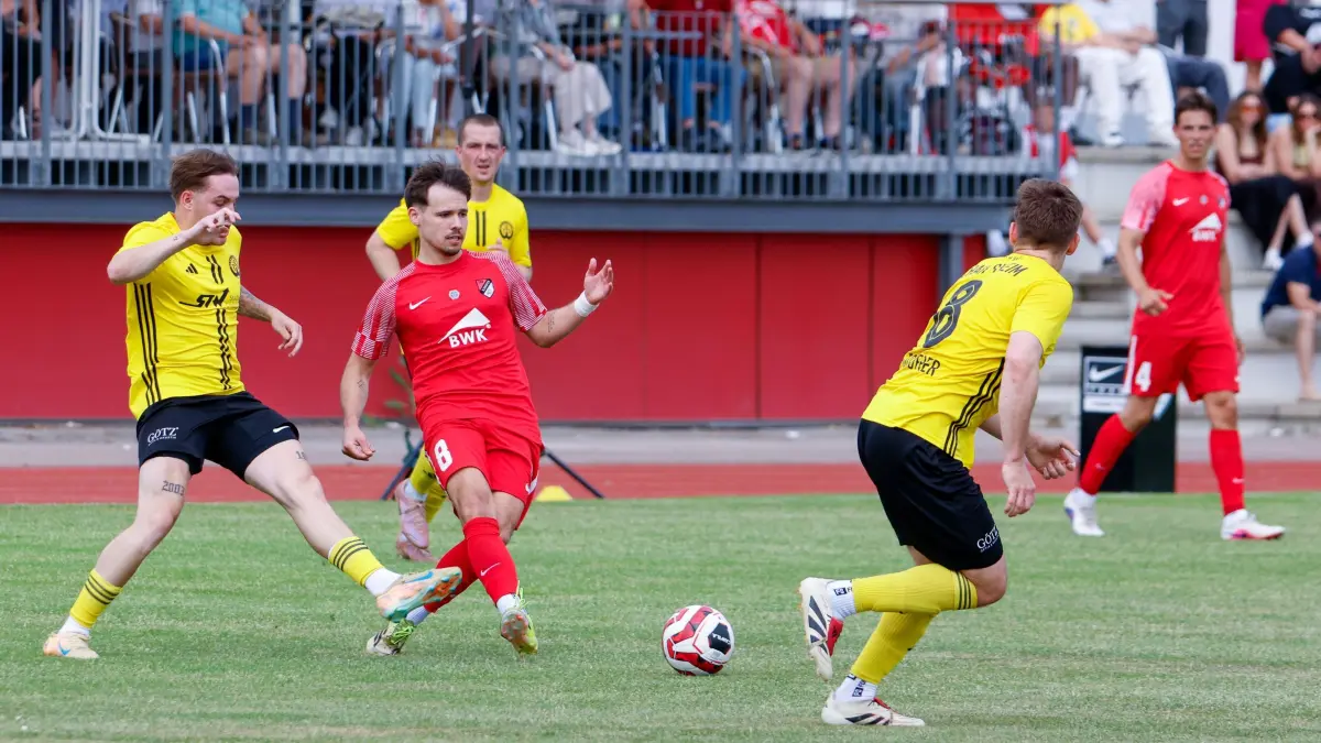 Ilshofens Aaron Rüger (rot) spielt einen Pass, während Crailsheims Louis Hermann (links) versucht, ihn noch zu stören. Das Landesliga-Derby endet mit 2:2.