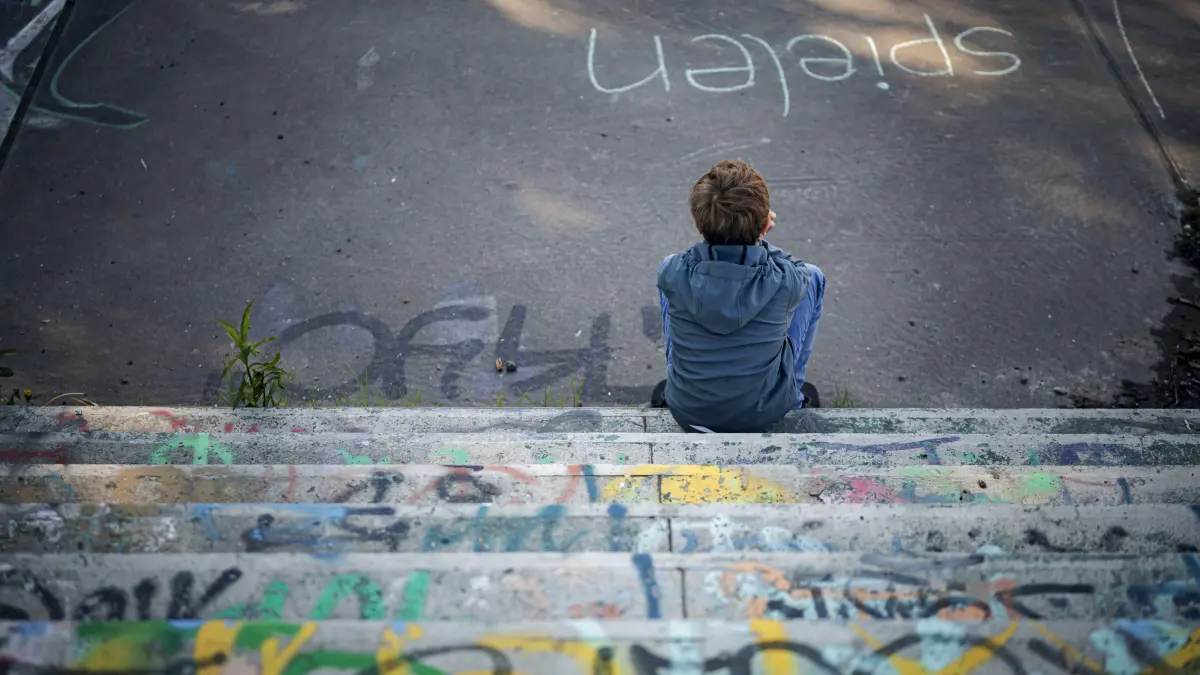 Einsame Kinder - Einsamkeit in der Kindheit: Gestellte Szene. Symbolfoto zum Thema Einsamkeit und Armut bei Kindern. Ein Junge sitzt alleine auf einem mit Graffiti bespruehten, heruntergekommenen Spielplatz. Glienicke, 08.05.2026. Glienicke Deutschland *** Staged scene Symbolic photo on the subject of loneliness and poverty among children A boy sits alone on a run-down playground covered in graffiti Glienicke, 08 05 2026 Glienicke Germany Copyright: xThomasxTrutschelx