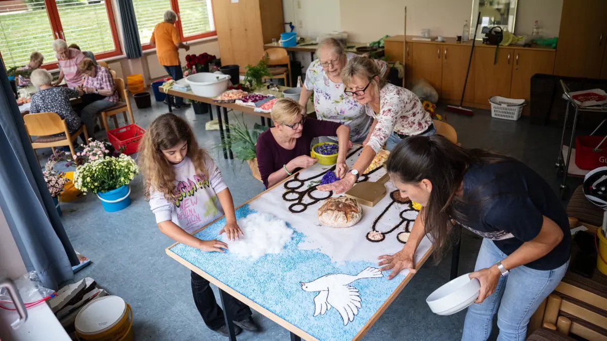 Einen Tag vor Fronleichnam helfen viele Frauen in Hirschau mit, den Blumenteppich für Fronleichnam zu legen.