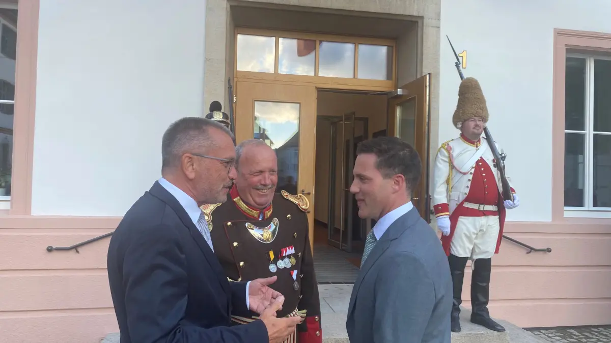 Innenminister Manuel Hagel wird am Mittwochabend in seiner Heimatstadt von Oberbürgermeister Alexander Baumann (l.) und Josef Stocker begrüßt. Stocker ist Kommandant der Historischen Bürgerwache der Stadt, die kurz darauf den Großen Zapfenstreich auf dem Marktplatz abhielt.