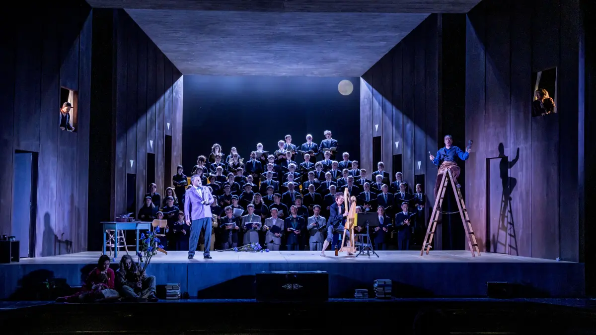 Das nächtliche Nürnberg im Theater Ulm: Hans Sachs (Dae-Hee Shin) sitzt auf der Leiter und kritisiert wütend Beckmessers (Joachim Goltz) Gesang – ein shakespearhafter Kobold (Gaëtan Chailly) spielt in Kay Metzgers Inszenierung die Harfe. Vorne kuschelt das Liebespaar Eva (Maryna Zubko) und Stolzing (Markus Francke).