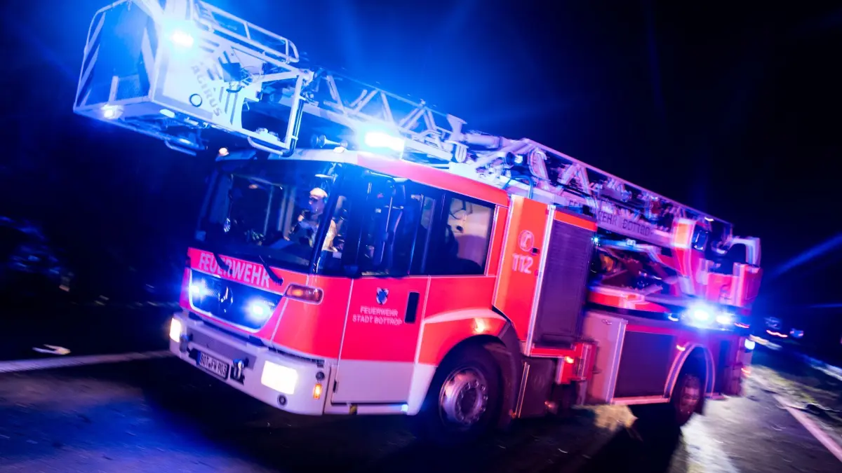 Brand in Mehrfamilienhaus: ARCHIV - 21.01.2018, Nordrhein-Westfalen, Bottrop: Ein Drehleiterwagen der Feuerwehr fährt mit Blaulicht an einer Unfallstelle vorbei. (zu dpa: «Fünf Schwerverletzte bei Wohnhausbrand in Hannover») Foto: Marcel Kusch/dpa +++ dpa-Bildfunk +++