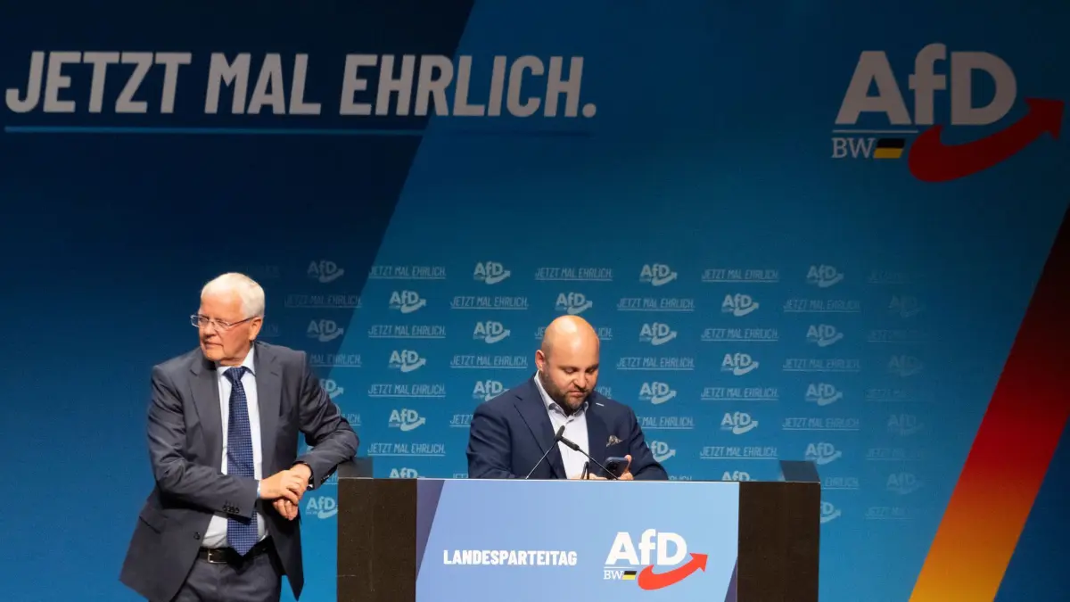 AfD-Landesparteitag Baden-Württemberg: 06.06.2026, Baden-Württemberg, Heidenheim: Markus Frohnmaier (AfD, r), Landesvorsitzender Baden-Württemberg, und Emil Sänze (AfD), Landesvorsitzender Baden-Württemberg, sind im Congress Centrum beim AfD-Landesparteitag an der Bühne. Foto: Stefan Puchner/dpa +++ dpa-Bildfunk +++