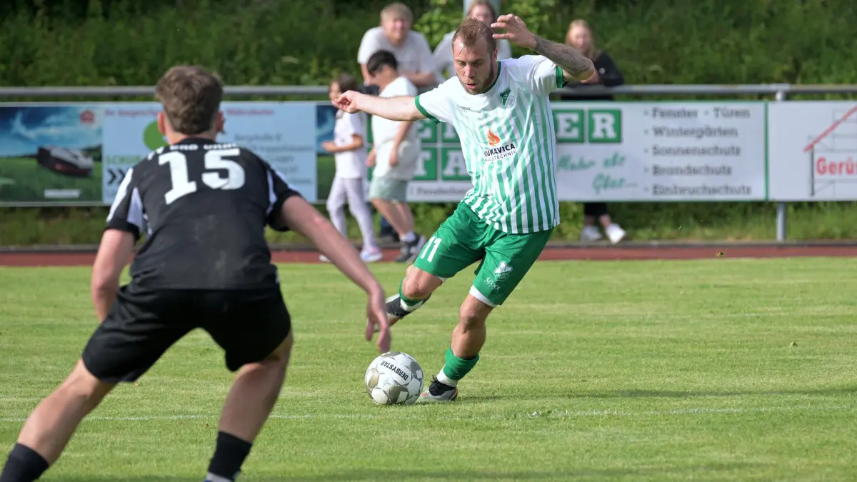 Fussball KL A | SV Huelben vs. FV Bad Urach: Fussball KL A1 | SV Huelben (gruen) vs. FV Bad Urach (schwarz) // 2026-06-06 // Foto: JoBaur // #11 Christian Locher (SV Huelben) beim/mit Pass auf #12 Dominik Neuherz (SV Huelben) / #15 k.A. (FV Bad Urach)