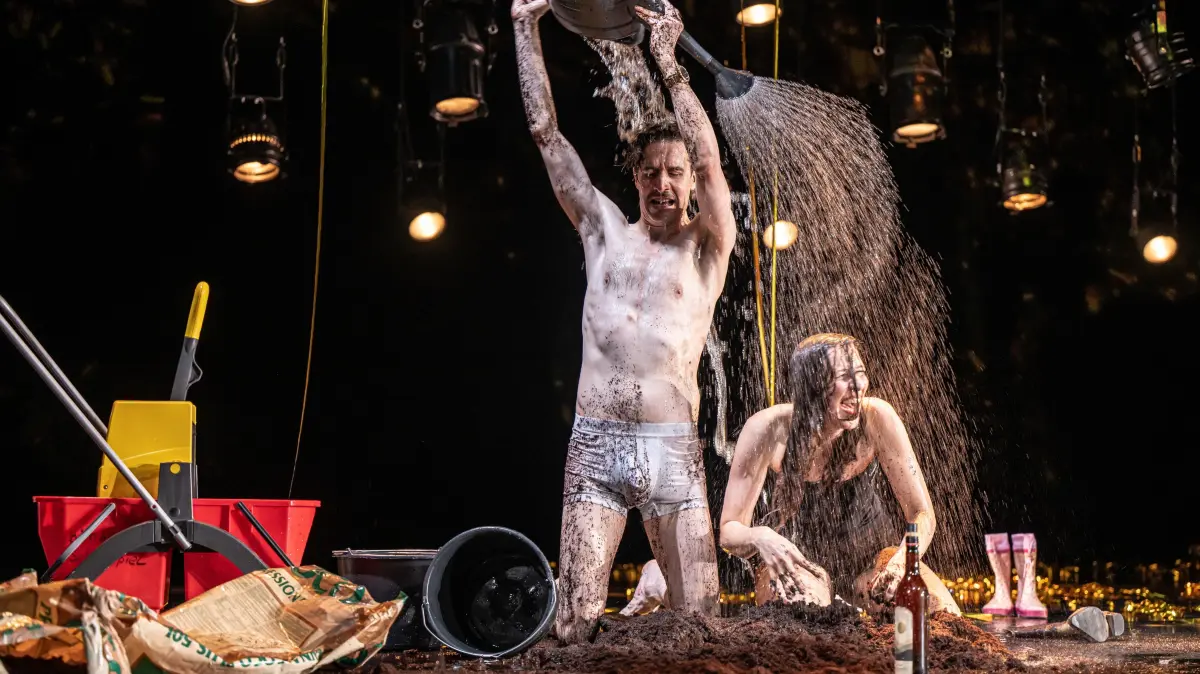 Marco Massafra (Victor) übergießt Katharina Hauter (Isabel) in Roland Schimmelpfennigs "Sommersonnenwende" mit Wasser.