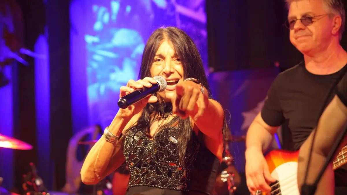 Mary Wild zeigt in Richtung Publikum. Oder Kamera. Oder Zukunft. Ganz sicher lässt sie keinen Zweifel daran, wer an diesem Abend das Mikrofon und die Aufmerksamkeit fest im Griff hat. Rechts daneben: Bassist und Bandgründer Rainer Konzelmann.