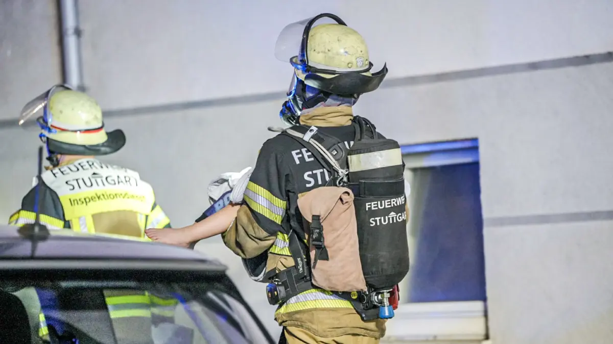 Ein Feuerwehrmann trägt in Stuttgart ein Kind aus einem Wohnhaus. In dem Hochhaus war in der Nacht auf Sonntag (07.06.2026) ein Brand im Keller ausgebrochen. Das Kind und fünf weitere Menschen wurden durch Rauchgase verletzt.