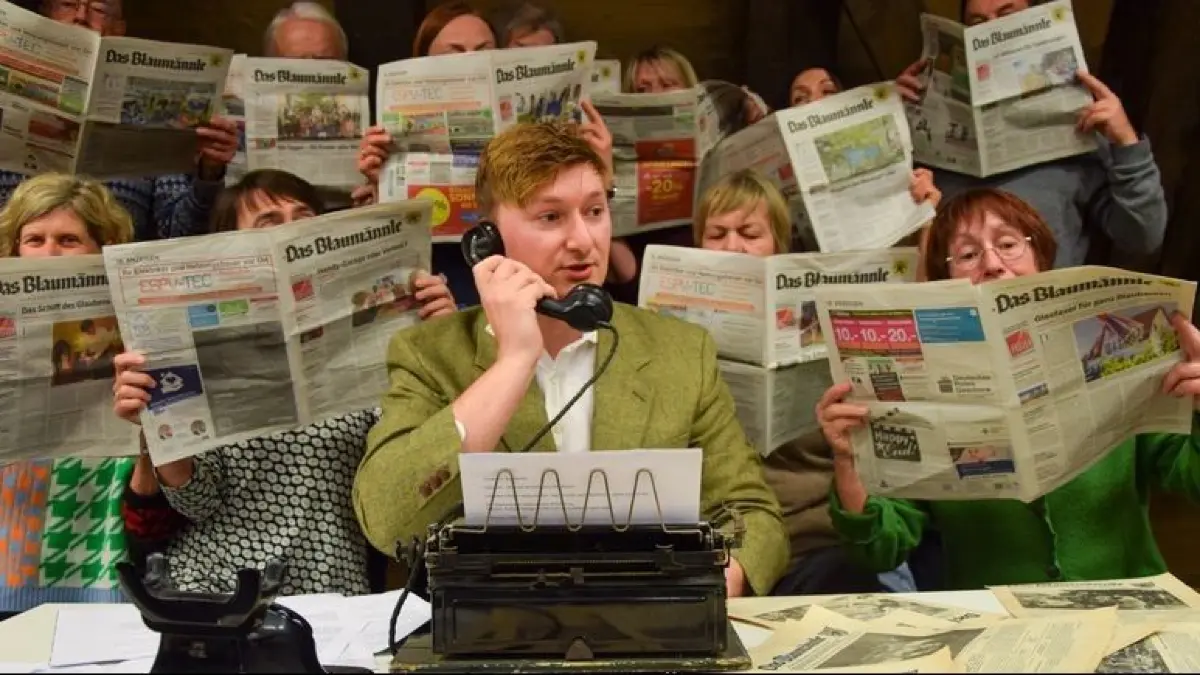 Szene aus den „Lehrjahren“ von Felix Huby, der darin über seine Arbeit im Blaumännle, dem Blaubeurer Nachrichtenblatt der SÜDWEST PRESSE schreibt. Das Stadttheater Blaubeuren bringt das Stück mit viel Aufwand auf die Sommerbühne am Blautopf.