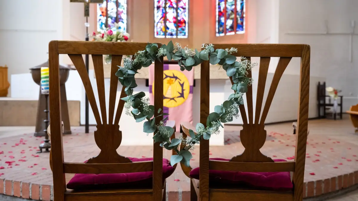 Aktion „Einfach heiraten“: ARCHIV - 23.03.2023, Bayern, Mnchen: Zwei Stühle mit einem Blumenkranz in Herzform sind bei der Aktion "einfach heiraten" in der Christuskirche zu sehen. In mehreren protestantischen Kirchengemeinden in Bayern können heiratswillige Paare sich an diesem Donnerstag spontan den kirchlichen Segen geben lassen. (zu dpa: «Einfach heiraten - Wo es bald Spontanhochzeiten gibt») Foto: Sven Hoppe/dpa +++ dpa-Bildfunk +++